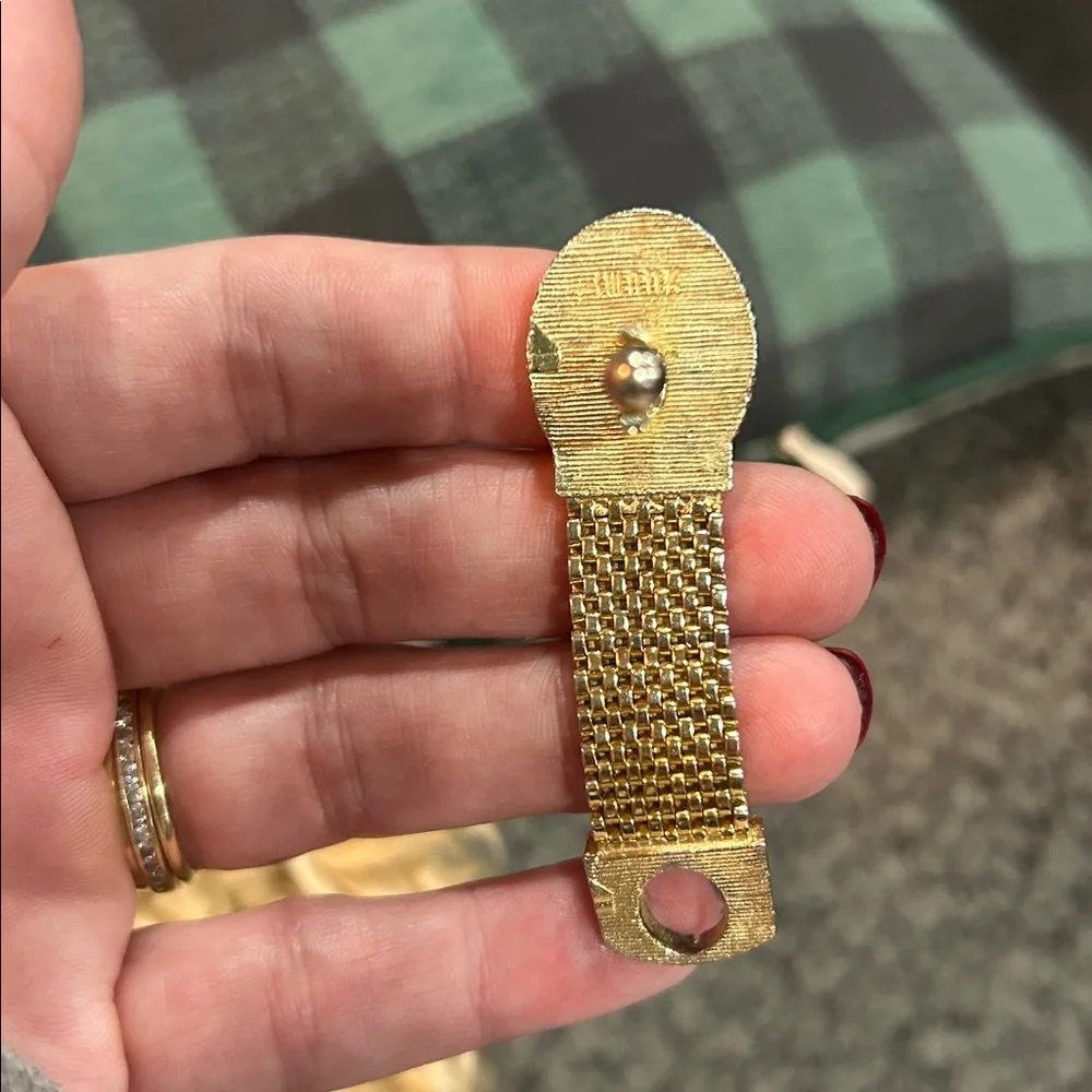vintage gold-tone woven mesh cufflink with a red rhinestone center.